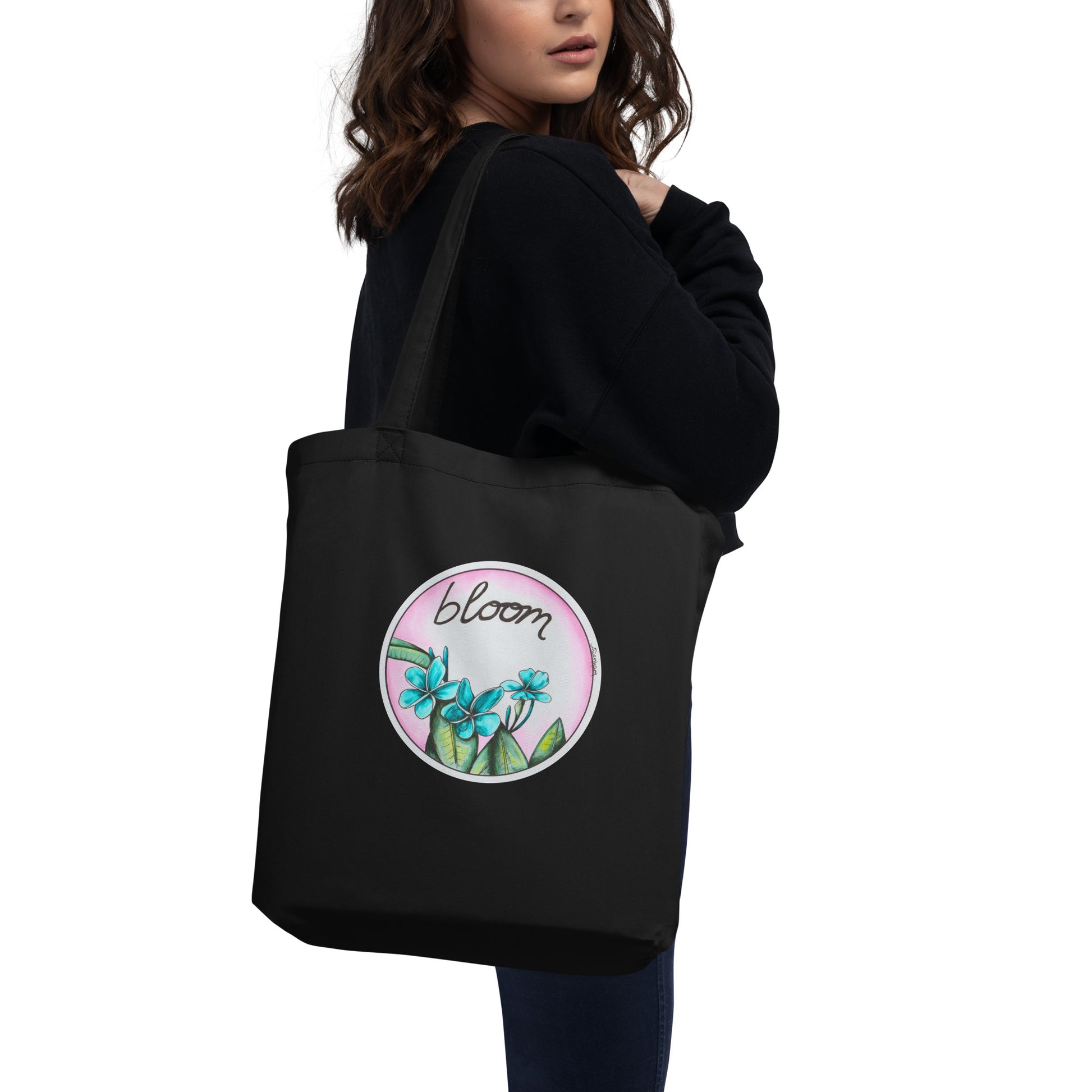 Amy-Lynn Denham's hand-drawn teal and pink tropical flowers bloom to life on this black eco-friendly tote bag