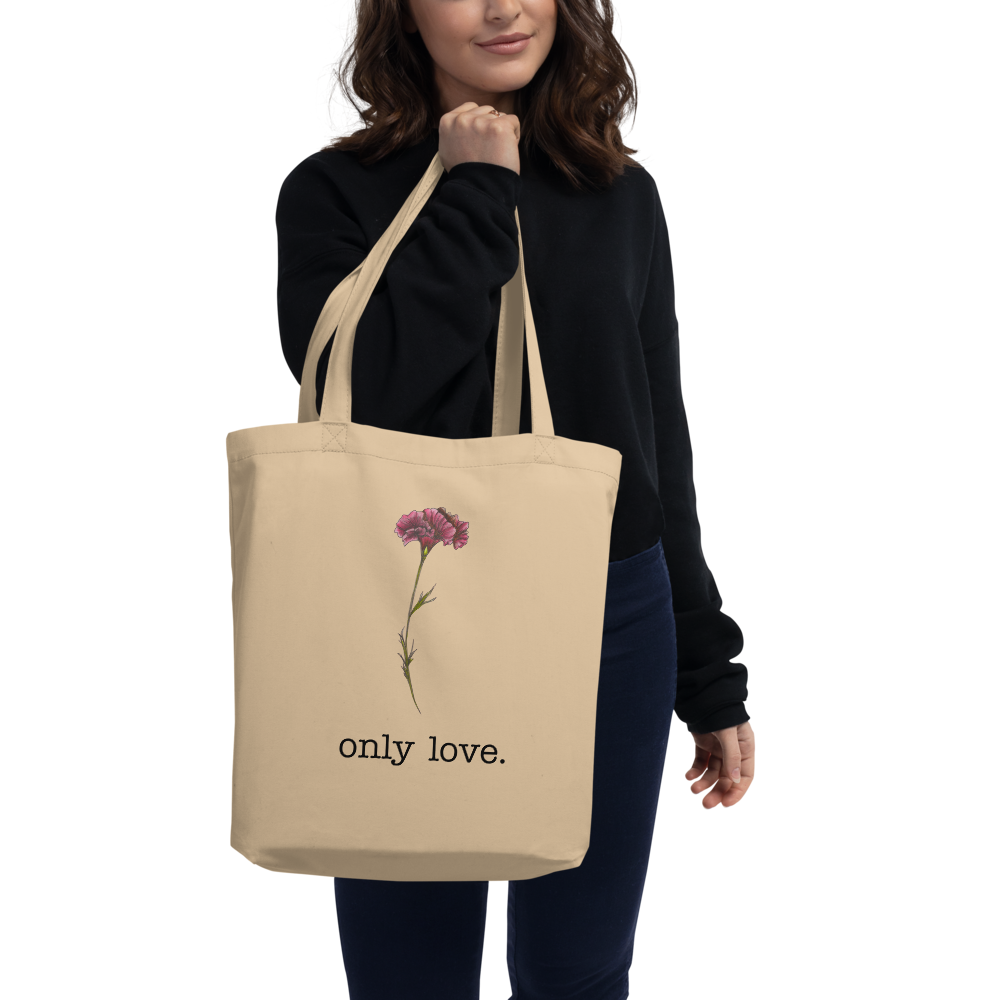Woman holding Amy-Lynn Denham's Only Love eco tote with hand-drawn pink carnation flower and typewriter font
